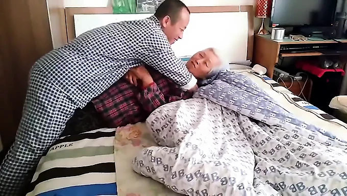 Elderly Asian lady and her younger partner in a homemade video