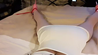 Laura, Adornata Con Un Seducente Abito Bianco, Nylon Rosa, E Calzature Sopraelevate, Legata E Zittata Su Un Letto